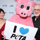 James Cromwell and Anna Stuart standing on either side of a costumed pig mascot holding a sign reading "I Love PETA"